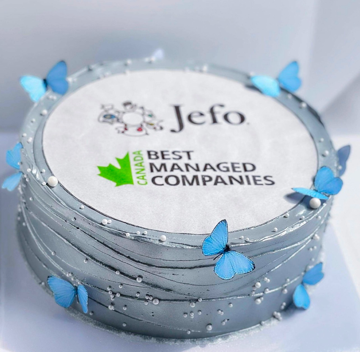 Jefo cake with blue butterflies celebrating Best Managed Companies Canada award in animal nutrition sector.