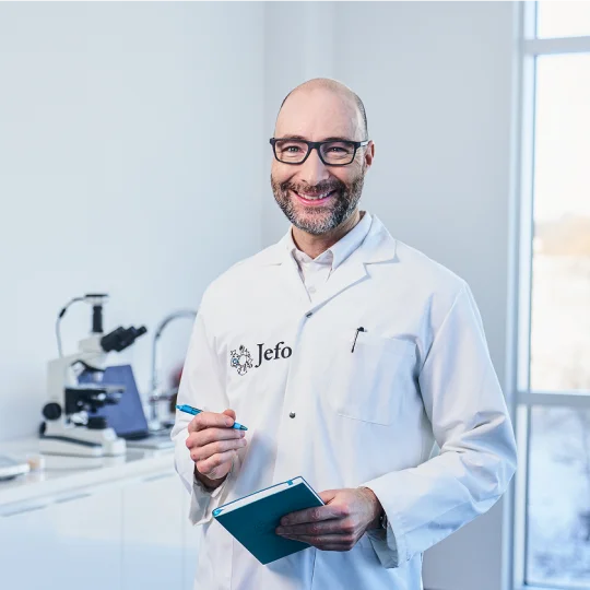 Smiling Jefo scientist in lab coat, embodying scientific rigor in advanced animal nutrition solutions.