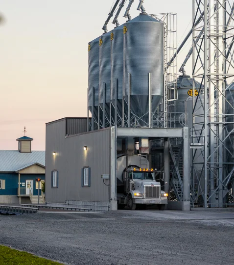 Truck under Jefo industrial silos, showing reliable logistics for delivering animal nutrition solutions globally.