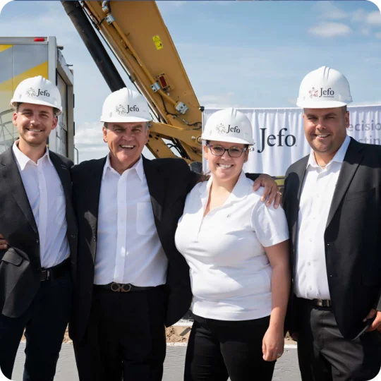 Smiling Jefo team in hard hats at groundbreaking ceremony for the new animal nutrition production facility.