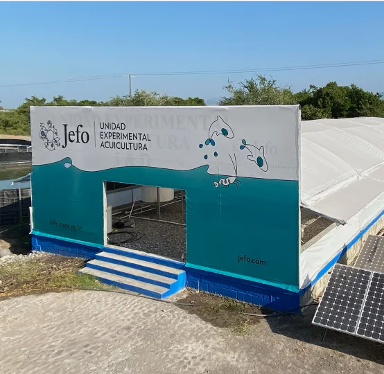 Jefo experimental aquaculture unit with covered research facility and solar panels in the foreground.