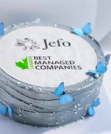 Silver cake with blue butterflies celebrating Jefo’s Canada Best Managed Companies award in animal nutrition.