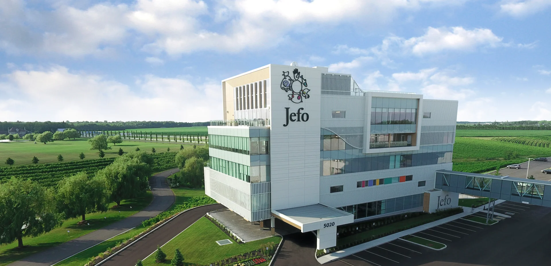 Campus moderno de Jefo rodeado de campos verdes, reflejo de innovación en nutrición animal sostenible.