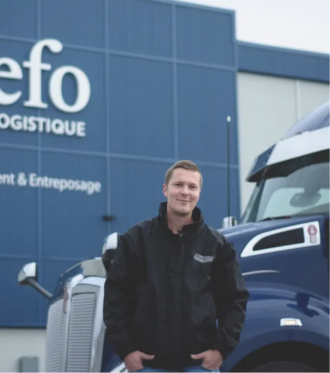 Nalaco driver standing by a blue truck at Jefo’s warehouse, specialized in animal nutrition logistics and ingredient delivery.